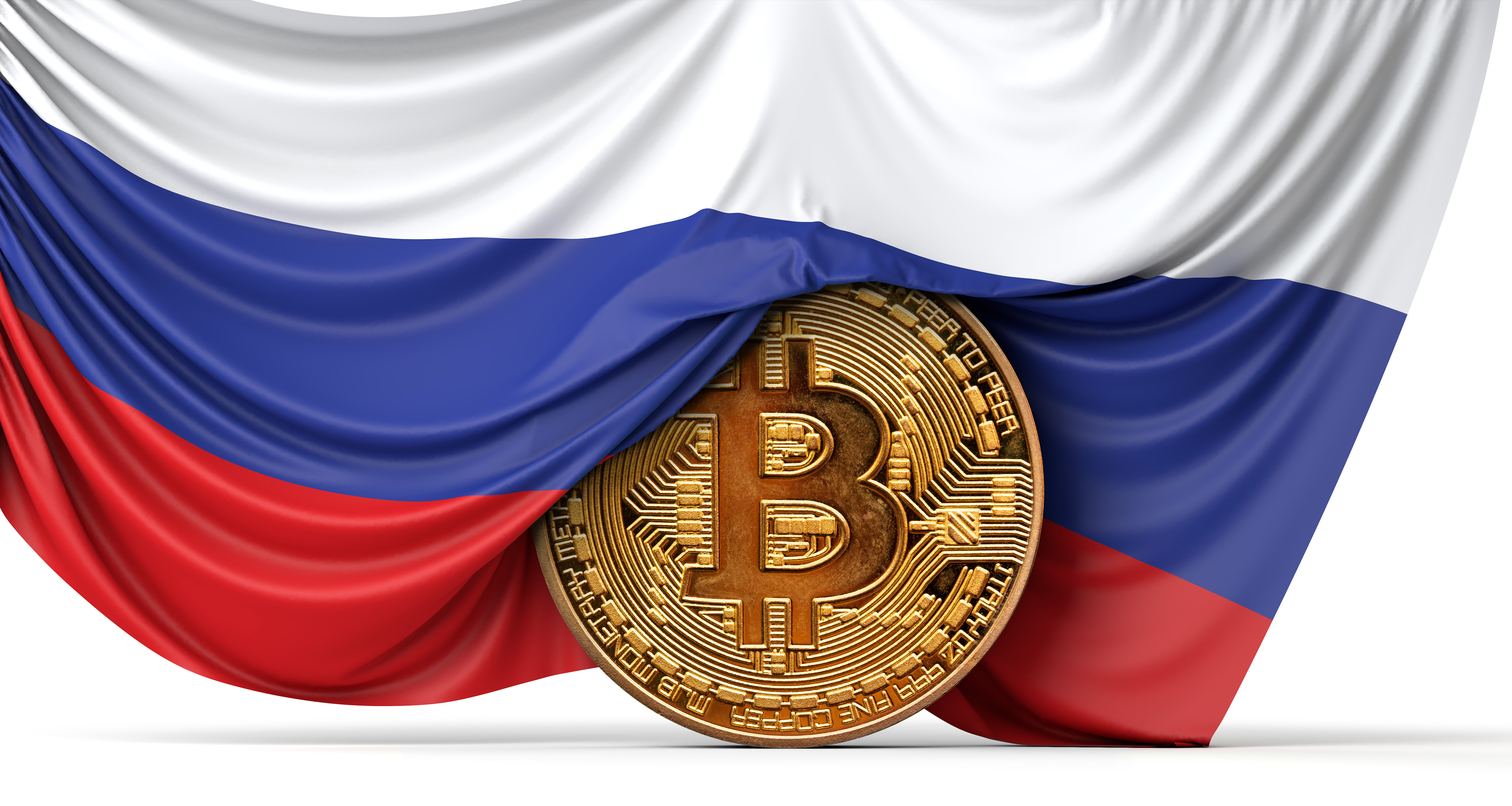 Un drapeau russe tombe sur une représentation en forme de pièce d'un jeton bitcoin.